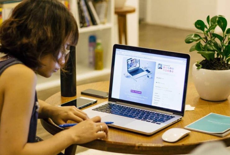 A person sitting at a table with a laptop.