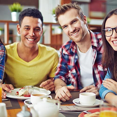 A group of people sitting at a table with plates.